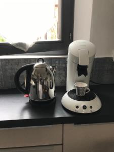 a coffee maker and a tea kettle on a kitchen counter at Au près de tout in Neuvecelle