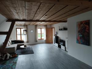 a living room with a wooden ceiling and a couch at Ferienwohnung Bruckmühle in Wasserburg am Inn