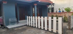 SengkolにあるBougenville Village Houseの白い柵の青い家