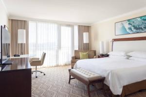 a hotel room with a bed and a desk and a chair at JW Marriott Marco Island Beach Resort in Marco Island