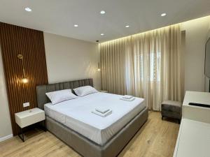 Postel nebo postele na pokoji v ubytování E&R Apartments at Myslym Shyri