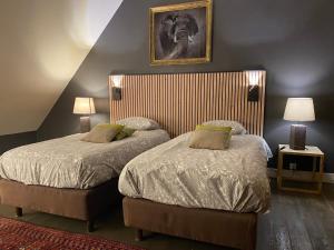 a bedroom with two beds and a picture on the wall at Le Soyeureux Holiday Cottage Villa Spa in Spa