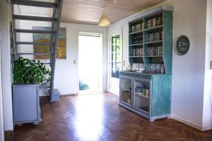 a living room with a book shelf with books at Dejligt og stort hus med spa og sauna in Roslev +25 photos