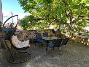 a patio with a table and chairs and a swing at Lydia's house in Agiá