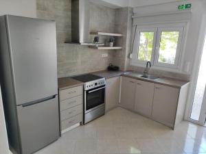 a white kitchen with a refrigerator and a sink at Lydia's house in Agiá