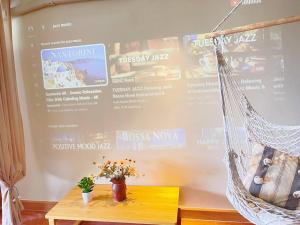 a hammock with flowers on a table in front of a wall at 912 Good view &2 minutes walk to one Nimman Maya in Chiang Mai