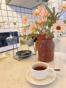 a cup of coffee and a vase with flowers on a counter at 912 Good view &2 minutes walk to one Nimman Maya in Chiang Mai