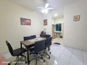 a dining room table with chairs and a ceiling fan at MIEA Guesthouse in Keningau