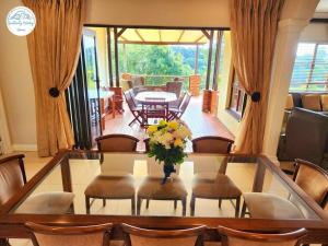 a dining room table with chairs and a vase of flowers at Villa P16 - Selborne Golf Estate in Pennington +42 photos