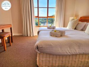 a bedroom with two beds and a desk and a window at Villa P16 - Selborne Golf Estate in Pennington