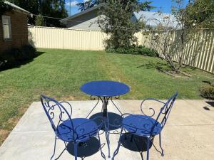 two chairs and a table with a blue table and chairs at Dalton Street Bungalow in Orange