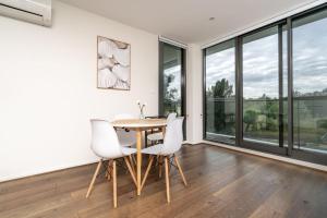 een eetkamer met een tafel en witte stoelen bij Stylish 2BR Apt 5 mins to Canberra Hospital - Hosted by Canstay in Phillip +20 foto's