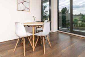 een eetkamer met een tafel en witte stoelen bij Stylish 2BR Apt 5 mins to Canberra Hospital - Hosted by Canstay in Phillip