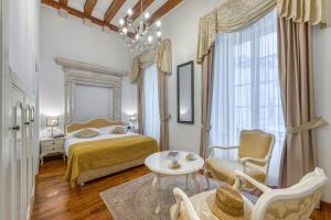 a bedroom with a bed and a table and chairs at Palmotta Palace in Dubrovnik