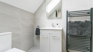 a white bathroom with a sink and a mirror at The Nook in Valley