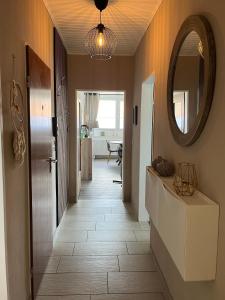 a hallway with a mirror and a tile floor at Ferienwohnung Voerde- Götterswickerhamm-am Rhein in Götterswickerhamm