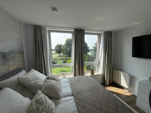 a bedroom with a bed and a large window at Chrisma Apartments in Düsseldorf