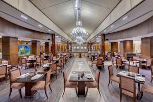 a restaurant with tables and chairs and a chandelier at Islamabad Marriott Hotel in Islamabad