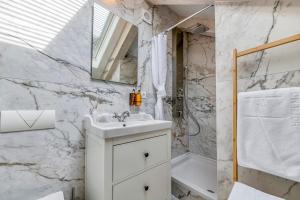 a white bathroom with a sink and a shower at Palmotta Palace in Dubrovnik +37 photos