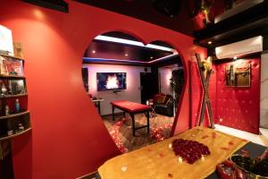 Pokój z czerwoną ścianą i stołem z winogronami w obiekcie Sensual Room Love Room Nancy Sauna Double Douche w Nancy +13 zdjęć