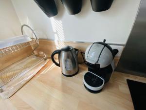 a coffee maker and a tea kettle sitting on a floor at Appartement 2 chambres in Mantes-la-Ville