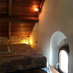 una camera con letto e finestra ad arco di Casa Torre Di Mactheus Petraro a Giovinazzo