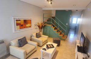 a living room with two couches and a staircase at Duplex Portugal Tw in Trelew