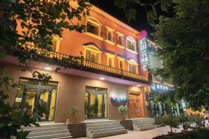 喀什红柳花天台花园民宿Red Willow Flower Hotel的建筑物在晚上点亮