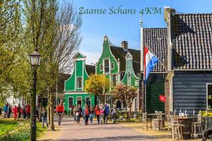 a group of people walking down a street in front of houses at Smile home 2, Zaanse schans and Amsterdam Appartements in Wormerveer
