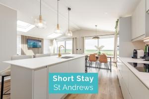 圣安德鲁斯Eden View Estate - Swilcan Lodge的厨房配有白色橱柜和厨房岛台,上面写着“短期住宿街厨房”