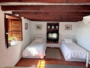 two beds sitting in a room with a tv at Sombrero de Pico C in El Paso