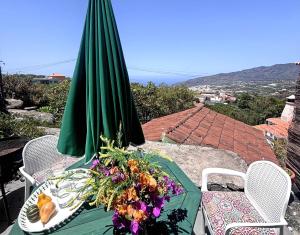 a table with a green umbrella and flowers on it at Sombrero de Pico C in El Paso