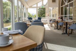 a restaurant with chairs and tables and windows at Skipton Hotel - formerly known as Hotel Rendezvous-Skipton in Skipton