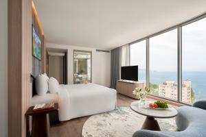 a bedroom with a white bed and a large window at Adamas Boutique Hotel Nha Trang in Nha Trang +111 photos