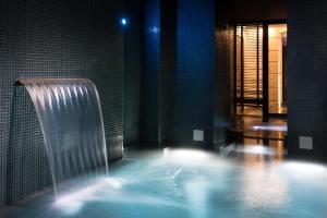 a bathroom with a shower and a tub with water at Hotel C2 in Marseille