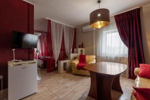 a living room with red curtains and a table at Duet Plus Motel in Voytovtsy
