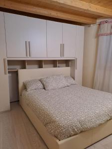 una camera da letto con un letto con armadi bianchi di La Casa di Allegra a Vione