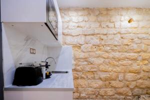 une pièce avec un mur de pierre à côté d'un comptoir dans l'établissement Luxurious Apartment with Stylish Design and Comfort - 105, à Paris