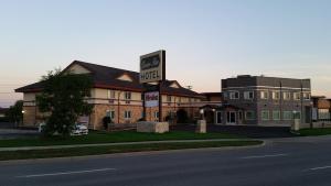 un hotel con un letrero al lado de una calle en Queen Bee Hotel en Winnipeg