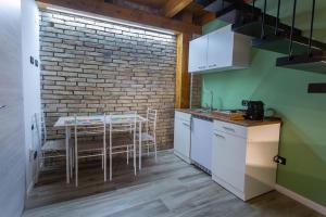kuchnia ze stołem i ceglaną ścianą w obiekcie Mini House w mieście Serra San Bruno +5 zdjęć