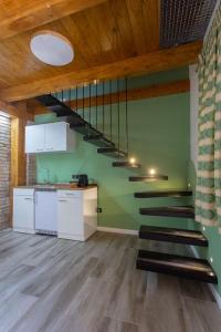 klatka schodowa w pokoju z zieloną ścianą w obiekcie Mini House w mieście Serra San Bruno