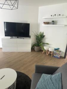 a living room with a flat screen tv on a white cabinet at Casa NICOLE in Malá Morávka