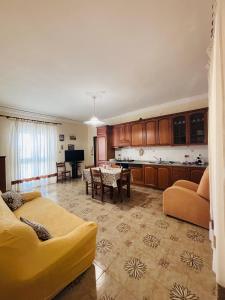 a large living room with a table and a kitchen at La sKALunATa-Borgo di Kalat-Affitti brevi per uso turistico in Siculiana