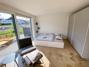una camera da letto con un letto, una sedia e una finestra di Lakeside Ermatingen a Ermatingen