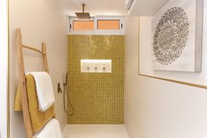 a bathroom with a shower with green tiles at Mouna's House in Tabaiba