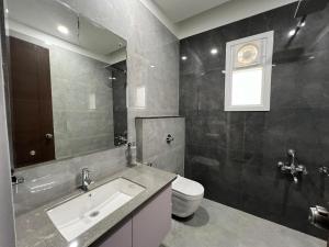 a bathroom with a sink and a toilet at Vaidehi Resorts in Ayodhya
