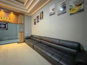 a living room with a leather couch on the wall at Hotel Dewata YIA Kulonprogo in Sindutan