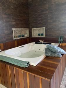 una bañera de hidromasaje en una habitación con paredes de madera en Pousada Casa Primitivus, en Pedra Menina