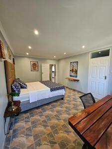 a bedroom with a bed and a wooden table at StoneWoodGrey in Harare