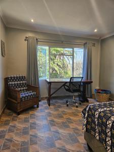 a room with a desk and a chair and a window at StoneWoodGrey in Harare